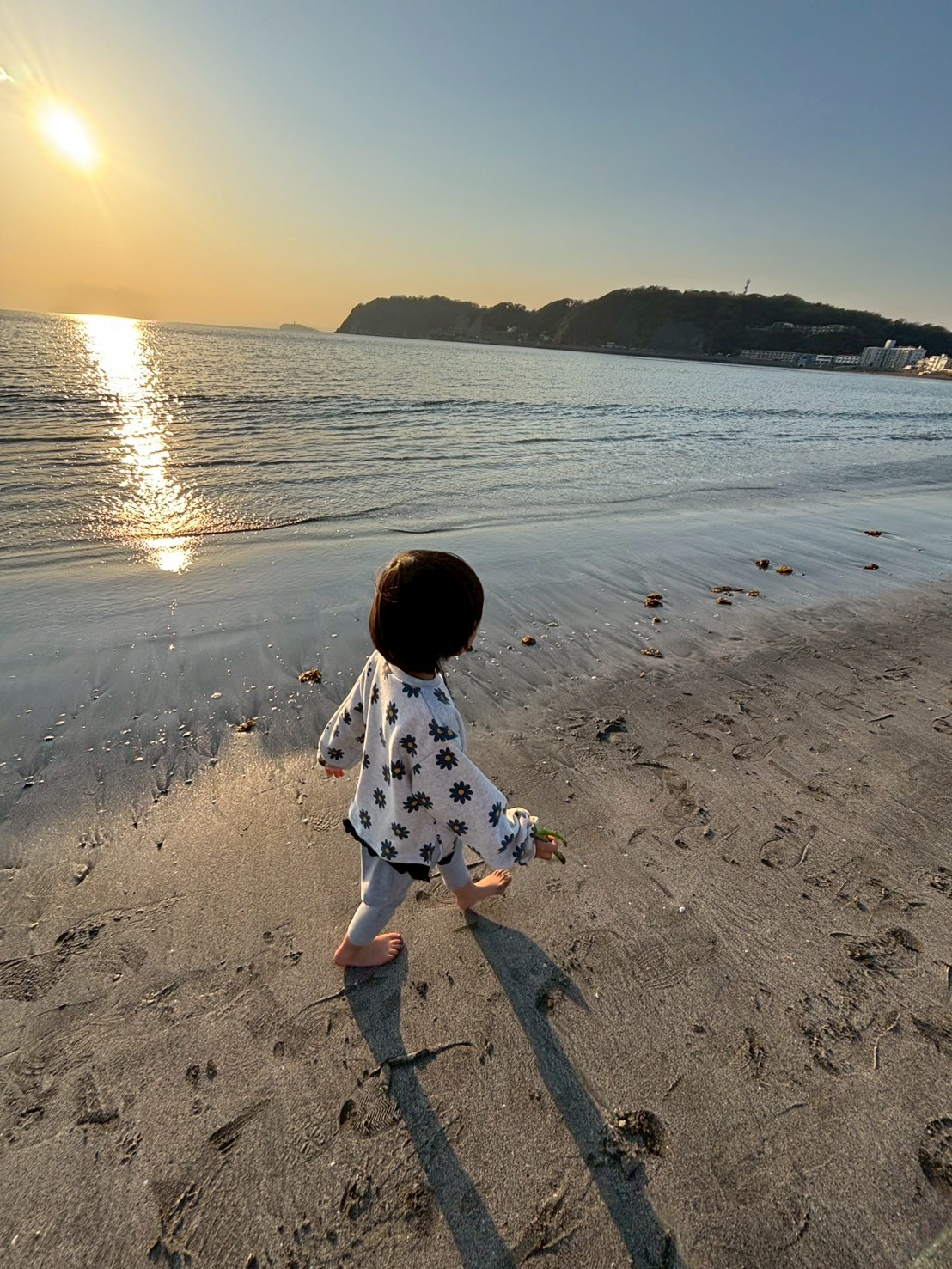 孩子赤腳走在沙灘上